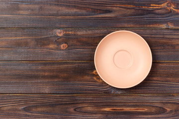 Orange round plate top view on a background of old wood table plank. matte round plate