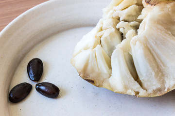 Seeds separated out from ripe cherimoya Annona cherimola fruit on a shallow dish, horizontal aspect