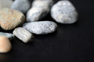 Fototapeta na wymiar Scattered stones on a dark background close up