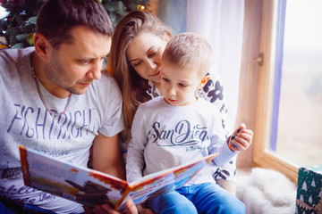 The father ,mother and  son reading a book