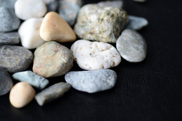 Fototapeta na wymiar Scattered stones on a dark background close up