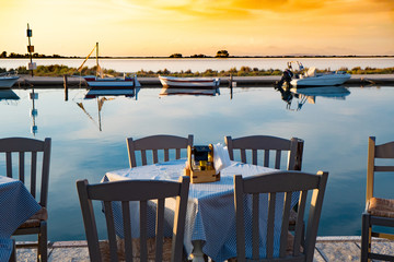 Traditional Greek tavern table near the sea at sunset