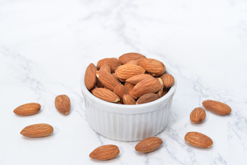 Almond in a bowl on white marble background
