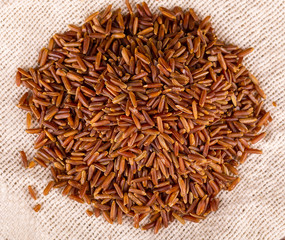 raw brown rice l on sackcloth background.