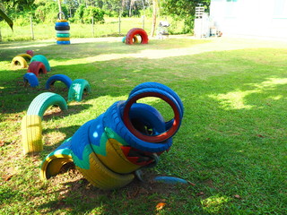 Playground with snake rubber wheels on green lawn