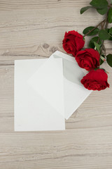 Valentines Day, Red roses and a blank invitation card  on wooden background, decoration for Valentines Day, wedding day concept
