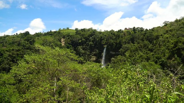 Tropical waterfall in green forest in jungle. Waterfall with natural swimming pool in a mountain river canyon. Philippines, Bohol. 4K video.