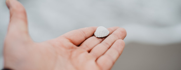 the man is holding a sea shell in his hand