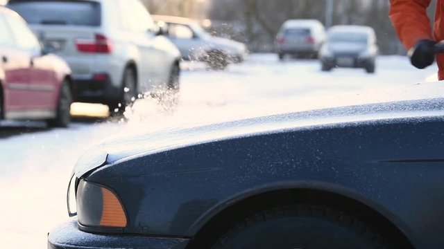man cleaning car from snow. slow motion