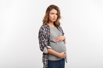 portrait of sad pregnant woman in casual clothing isolated on grey