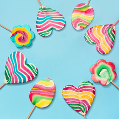 Set of rainbow colorful candy isolated on blue. Top view. Copy space. Square.