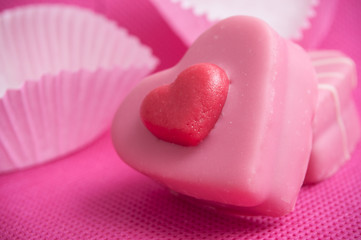 petits four en forme de coeur sur fond rose pour la st valentin