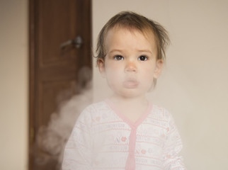 Sad child in the smoke. Danger of passive smoking concept.