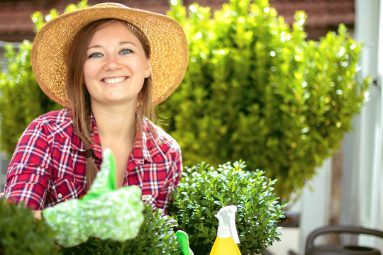Fr&ouml;hliche Frau im Garten beim Pflanzenpflege