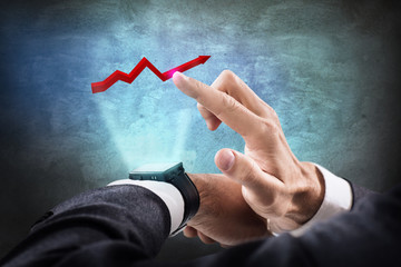 Businessman touching virtual graphic icon from smartwatch.