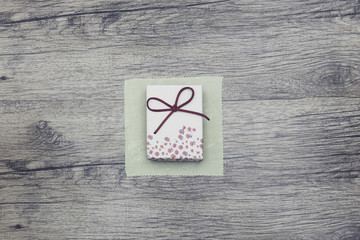 Single white gift box on bright wood background