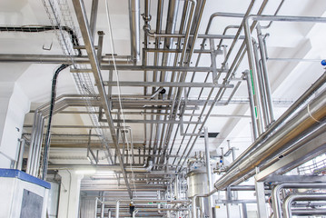 Stainless steel pipes in the factory. Construction on food production, Abstract industry background.