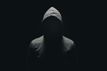 faceless man in hoodie standing isolated on black - Powered by Adobe
