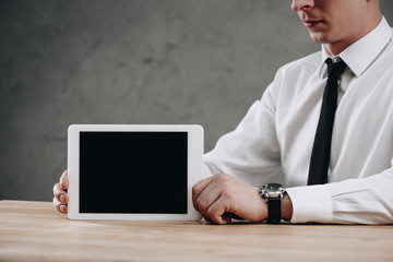 partial view of businessman holding digital tablet with black screen