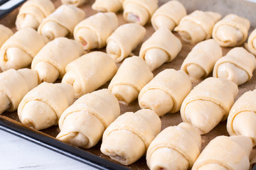 Making small homemade croissants in the kitchen on a baking sheet