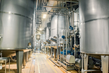 Large stainless steel barrels connected by pipes in the factory industry