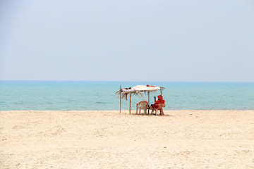 Fototapeta na wymiar Tropischer Strand am Meer mit rotem Rettungsschwimmer 