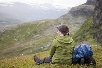 A hiker in the mountains rests and enjoys the view 