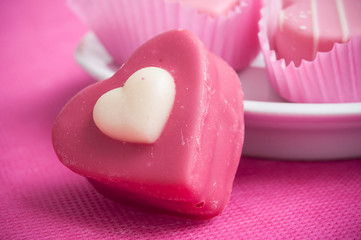 petits four en forme de coeur sur fond rose pour la st valentin