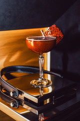 Cocktail with gold on a dark background with fruit chips