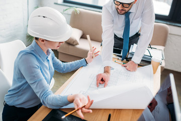 high angle view of architects working with building plan at office