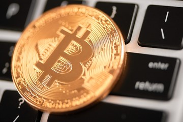 Closeup of golden bitcoin as main virtual currency placed on laptop keyboard. Cryptocurrency virtual digital money web electronic currency blockchain future trends mining exchange innovation finance