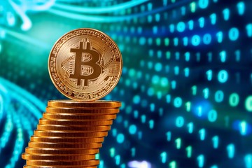 Stack of golden bitcoins with one bitcoin on its edge placed on blurred blue background. Digital virtual money blockchain stock exchange future finance innovative banking web business