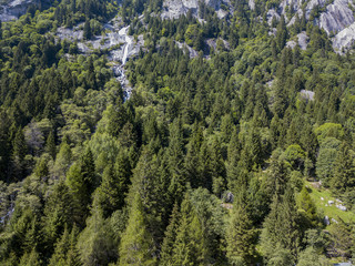 Vista aerea di una cascata in Val di Mello, una valle verde circondata da montagne di granito e boschi, ribattezzata la Yosemite Valley italiana. Val Masino, Valtellina, Sondrio. Italia