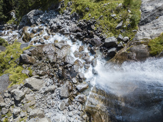 Vista aerea di una cascata in Val di Mello, una valle verde circondata da montagne di granito e boschi, ribattezzata la Yosemite Valley italiana. Val Masino, Valtellina, Sondrio. Italia