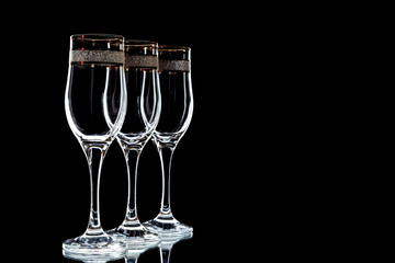 a few glasses of wine with a gold rim  on a black background (isolate).