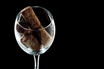 a glass of wine with plugs inside close-up. the glass is on a black background (isolate).