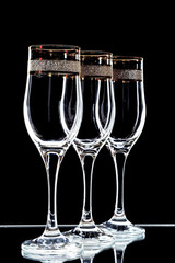 a few glasses of wine with a gold rim  on a black background (isolate).