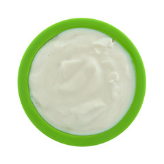 Top view of a small green bowl filled with caramel yogurt isolated on a white background.