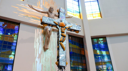 brown cross with Jesus Christ from amber inside the church © Bartosz