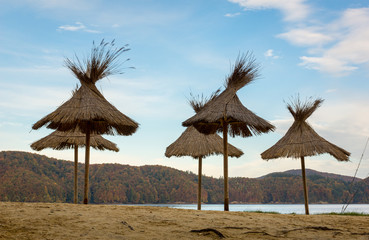 Wooden umbrellas on the beach by the Solina lake in Polanczyk, Bieszczady, Poland