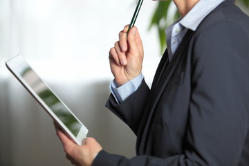 Frau im Anzug arbeitet an Tablet