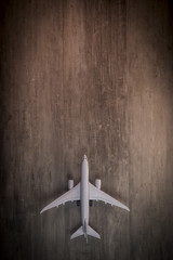 White blank toy of passenger plane on rustic wooden background