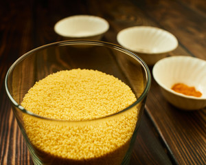 Couscous on a background of spices in bowls.