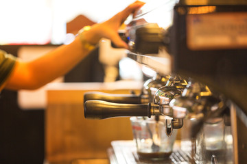 close up of worker using coffee machine to make coffee in resturant