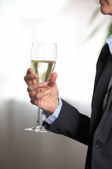 Hand hält ein Glas mit Champagner