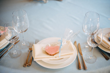 White plates on blue tablecloth, pink and blue heart form cookies on plates