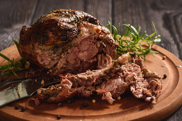 Roasted lamb fillet on wooden background.