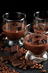 Chocolate, coffee, creamy liqueur, cocktail with coffee beans, chocolate and cinnamon. On a black background. Christmas alcoholic drink