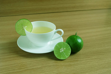 Freshly Lime juice in a white cup on wooden floor