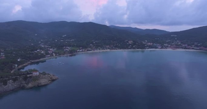 Aerial, island coast with beautiful calm sea in the evening and overcast sky